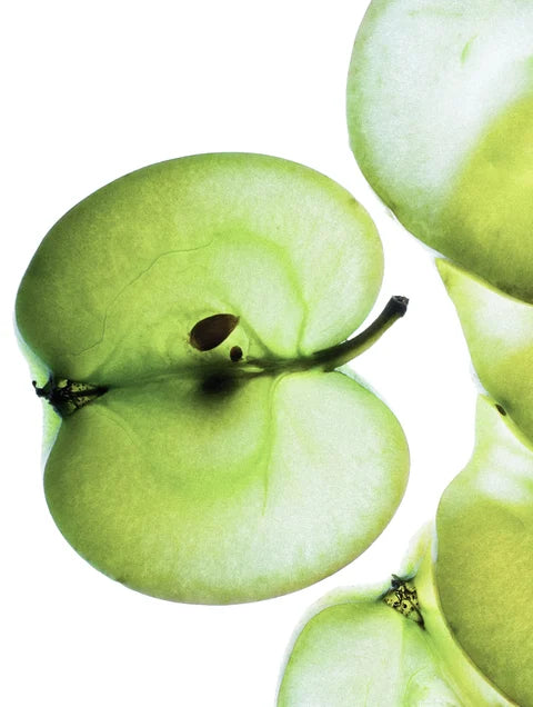 Fresh green apple slices representing apple extract in Exosome & Niacinamide Serum