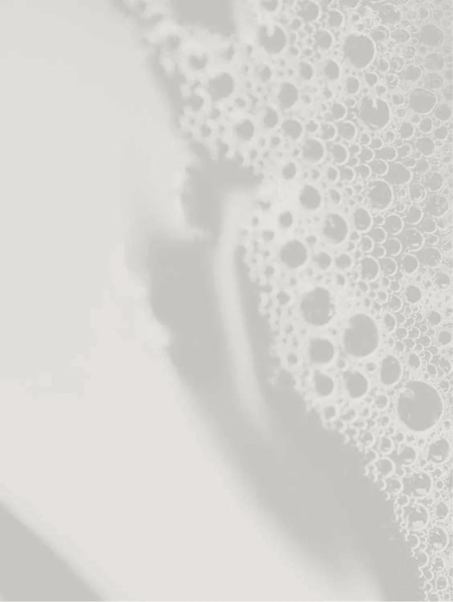 Close-up of white cleansing foam and bubbles on a light background