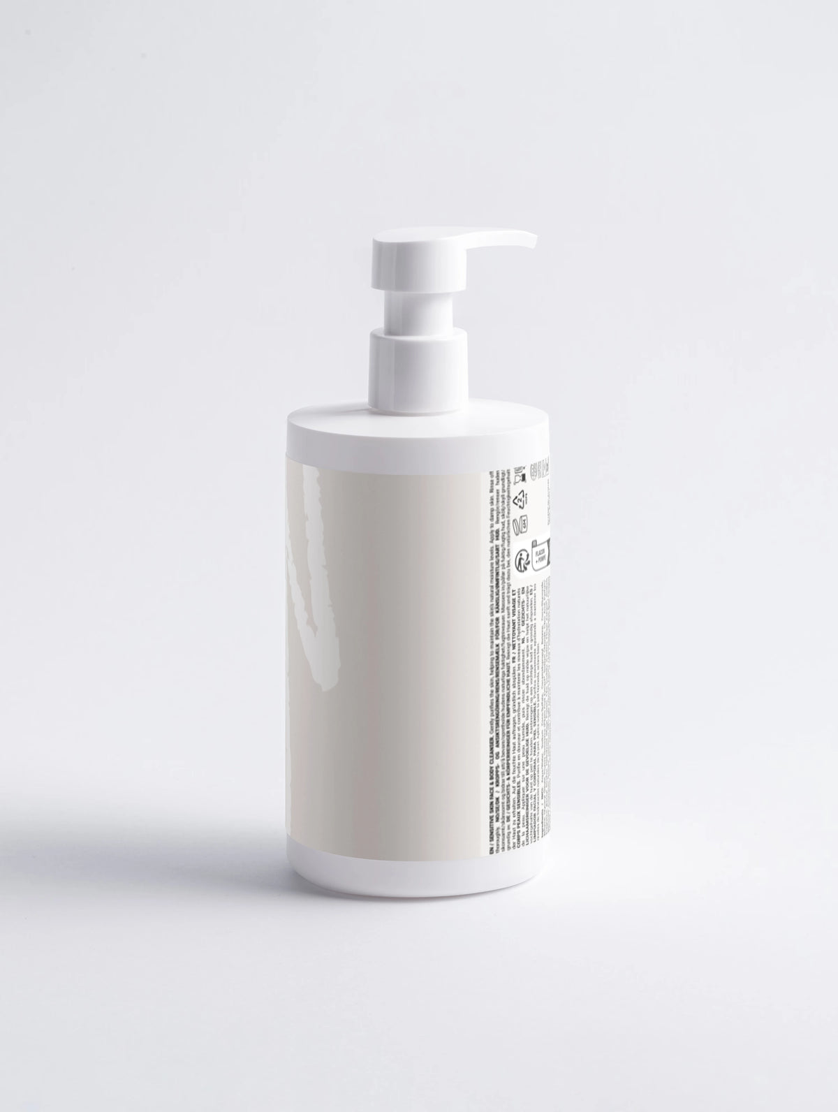 Rear view of a white Lueur Beauté Sensitive Skin Face & Body Cleanser pump bottle showing the ingredient and information label on a light background