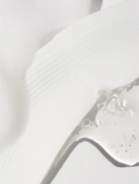 Close-up of a white creamy smear beside a transparent gel-like texture containing small air bubbles.