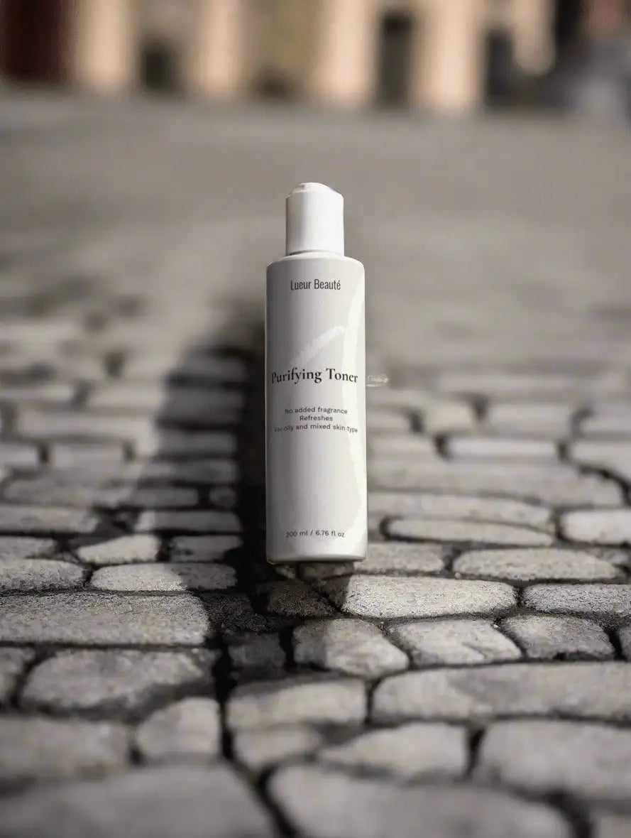 Lueur Beauté Purifying Toner standing on cobblestone street with blurred city background