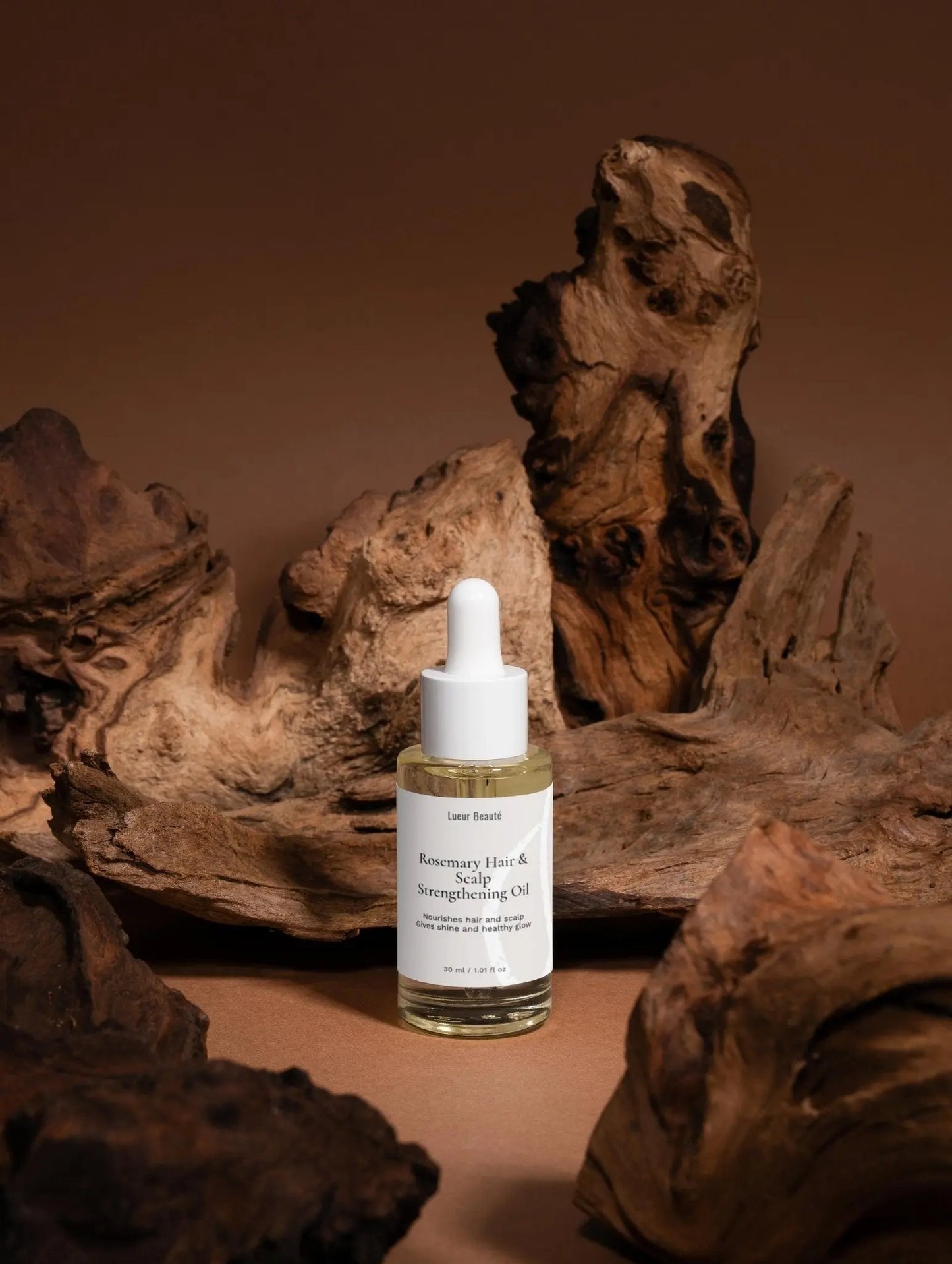 Lueur Beauté Rosemary Hair & Scalp Strengthening Oil bottle for thicker, healthier hair.
